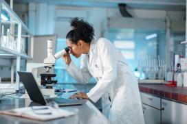 Scientifique qui regarde dans un microscope dans un laboratoire - Hépatite associée à l'alcool - Hôpital universitaire de Bruxelles